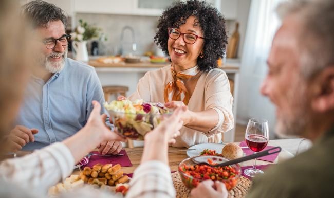a group of people sitting around a table with food