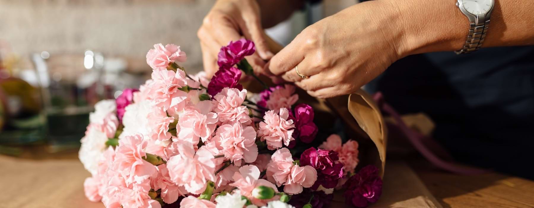 a person placing flowers on a table