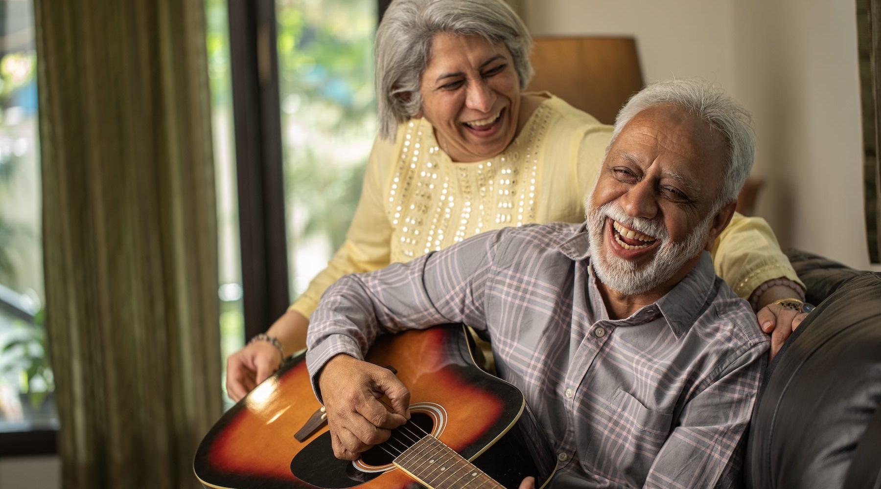 a couple playing a guitar in a living room