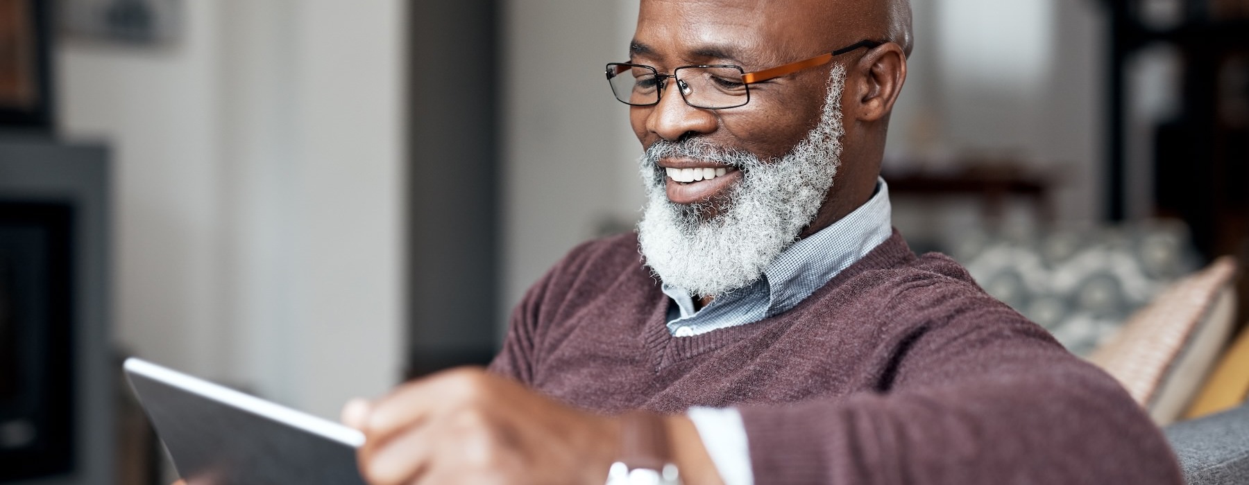 a man with a beard and glasses holding a tablet