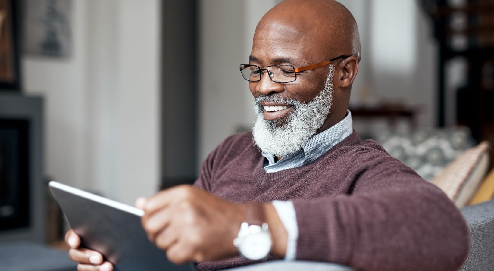 a man with a beard and glasses holding a tablet