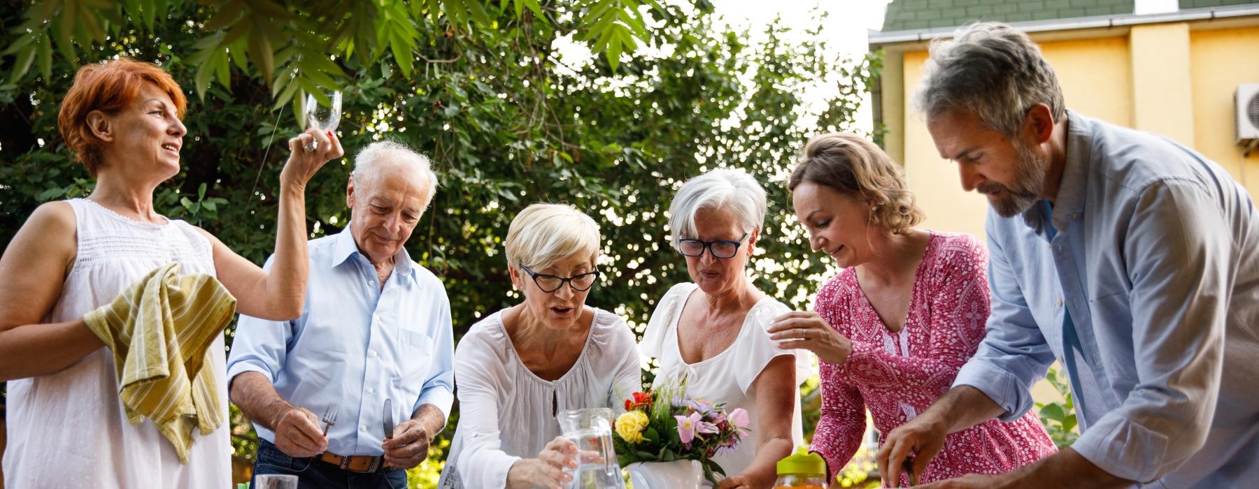 a group of people standing around a table with flowers